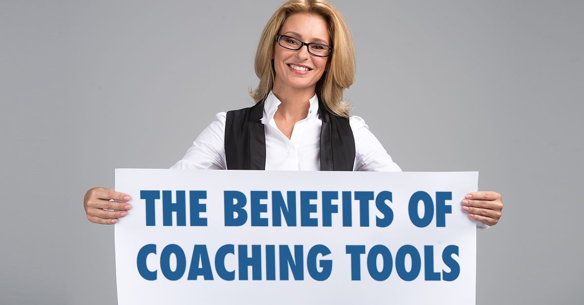 Coach holding sign that says The Benefits of Life Coaching Tools