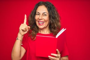 Coach Pointing Excited Reading a book on red background